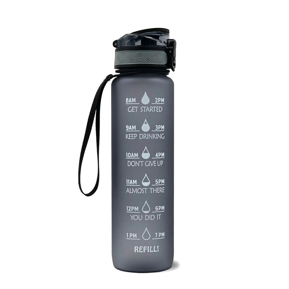 Blue-red gradient 1L Tritan water bottle with time markers and flip-top lid on a gym bag