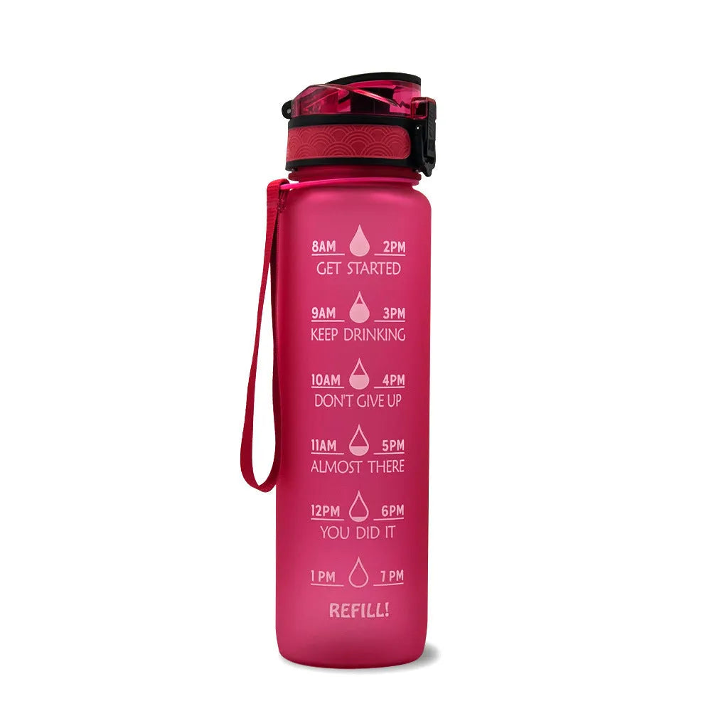 Blue-red gradient 1L Tritan water bottle with time markers and flip-top lid on a gym bag