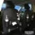 Black PU leather car seat organiser with multiple pockets hanging on a car headrest