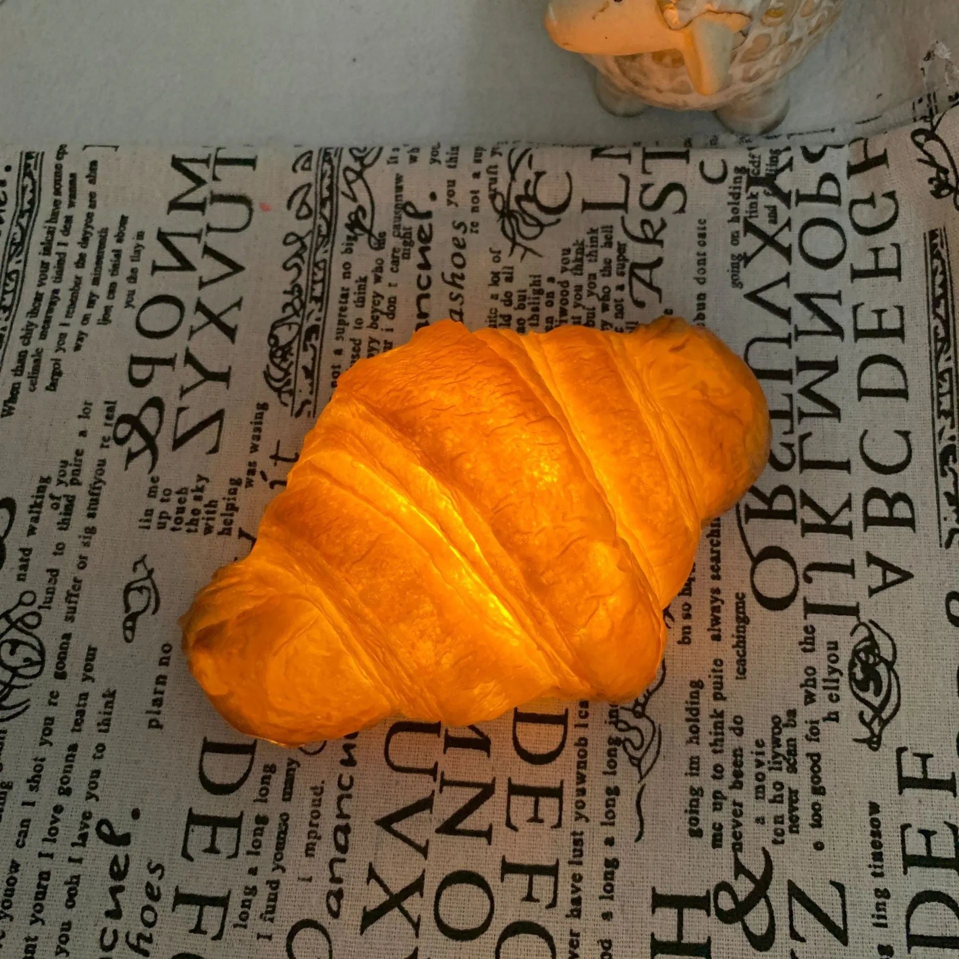 Creative LED night light shaped like a croissant or bread on a table
