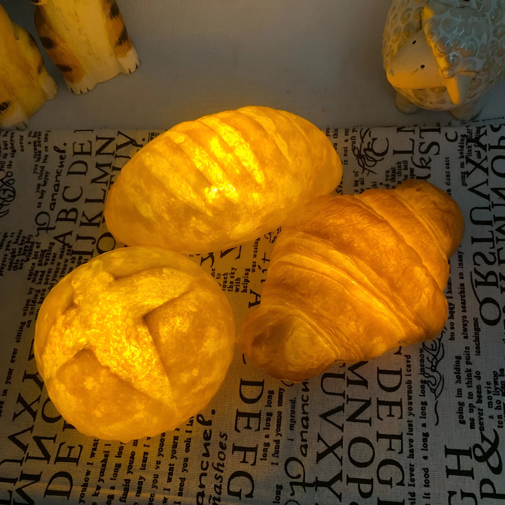 Creative LED night light shaped like a croissant or bread on a table
