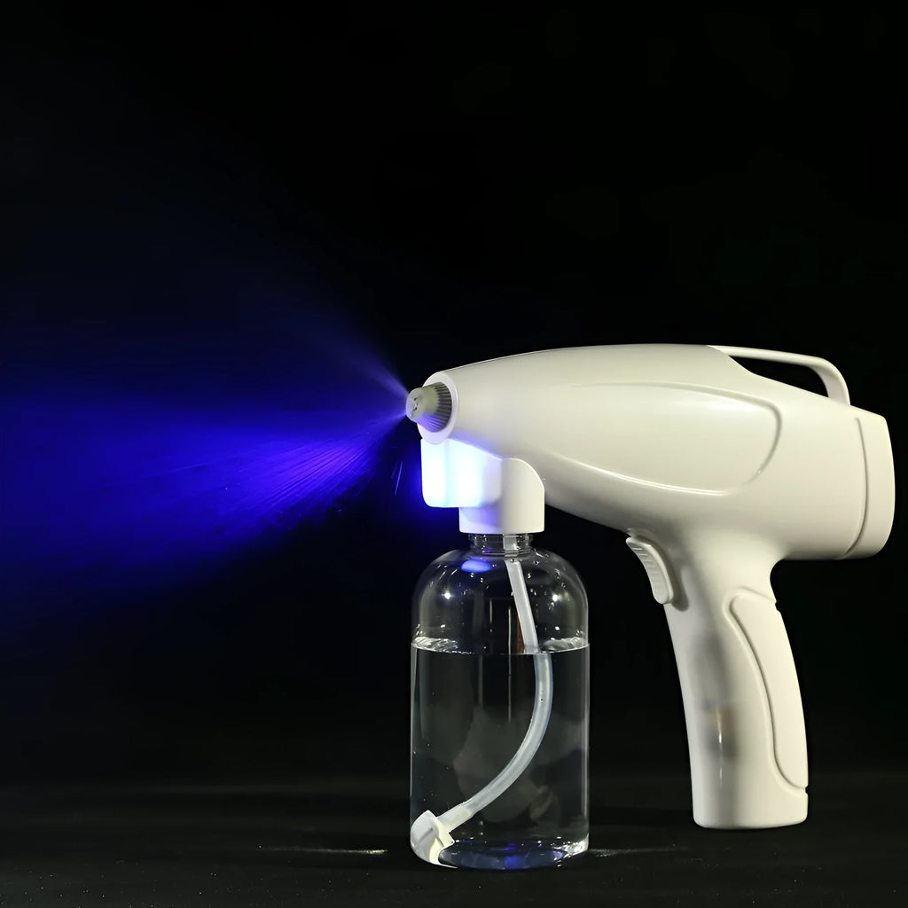 White handheld wireless electric spray disinfection gun with USB-C port and bottle attached