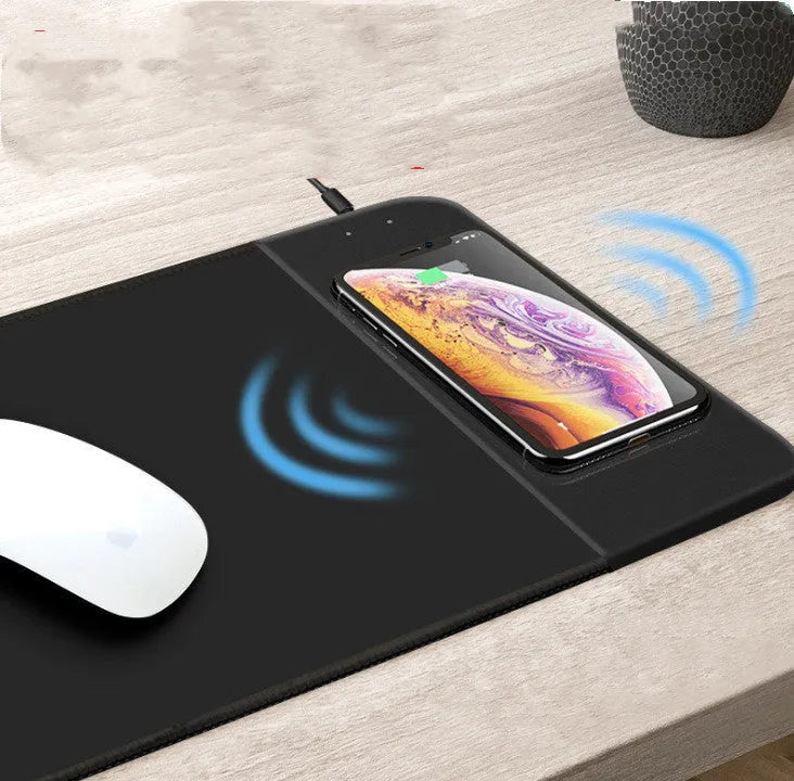 Black wireless charging mouse pad with RGB lighting on a desk