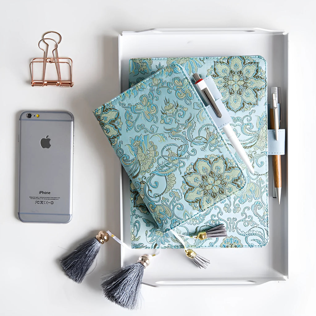 Fabric cover notebook with flying blue flowers pattern in A5 and A6 sizes on a desk.