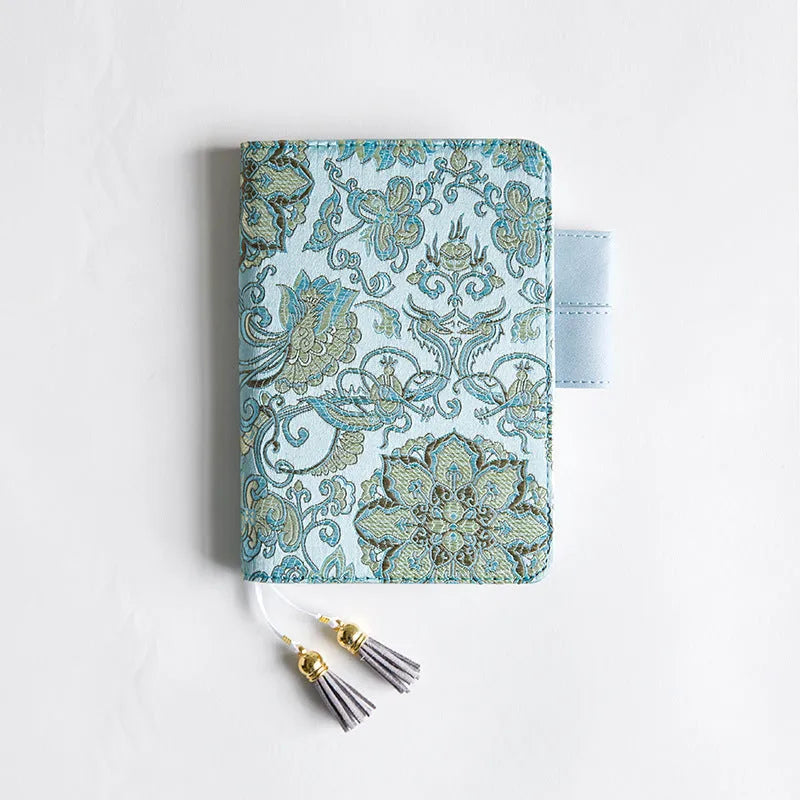 Fabric cover notebook with flying blue flowers pattern in A5 and A6 sizes on a desk.