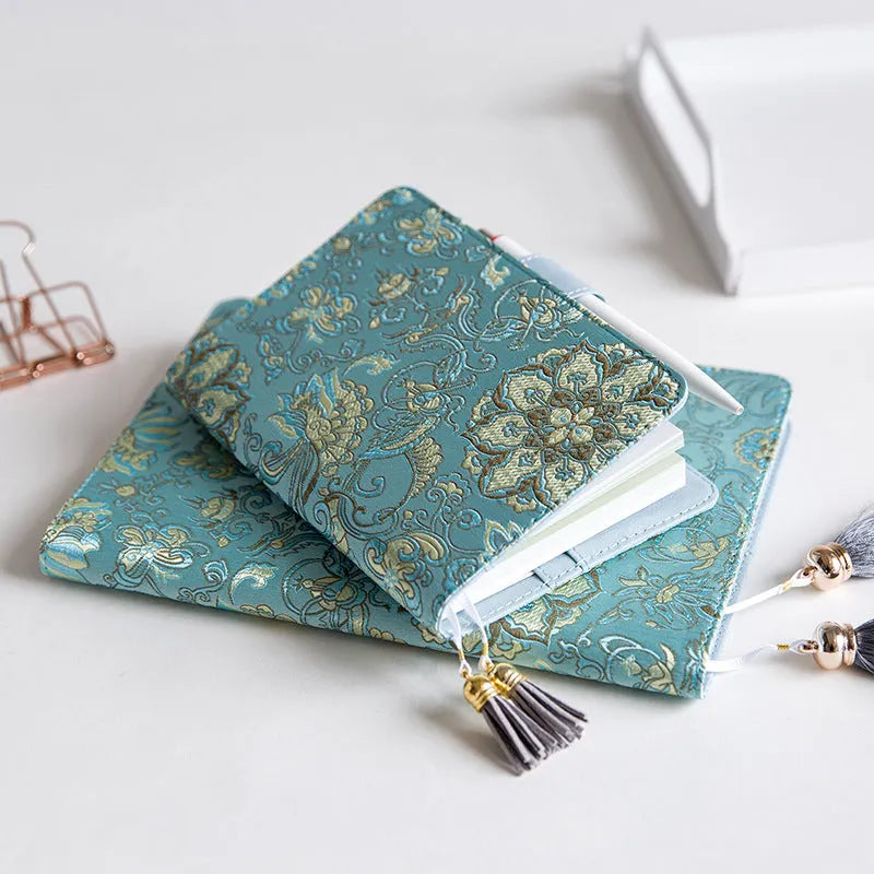 Fabric cover notebook with flying blue flowers pattern in A5 and A6 sizes on a desk.