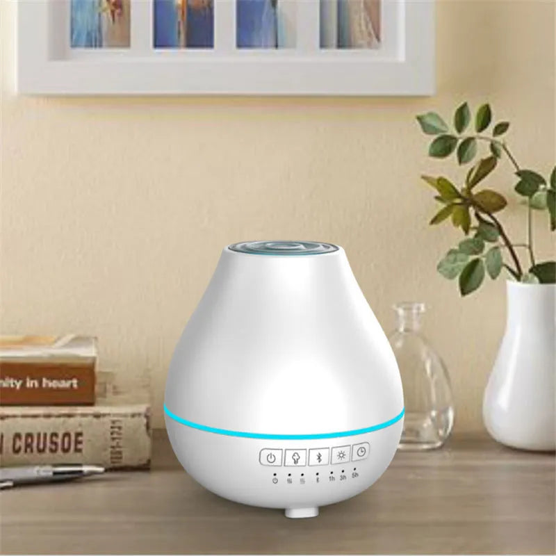 White round Bluetooth humidifier and aroma diffuser with night light on a wooden table, emitting mist.
