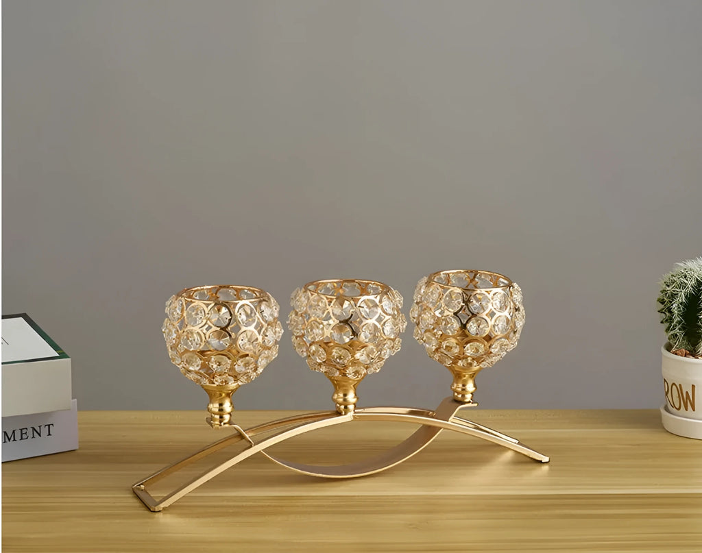Geometric crystal candle holder with gold electroplated wrought iron frame on a table