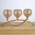 Geometric crystal candle holder with gold electroplated wrought iron frame on a table