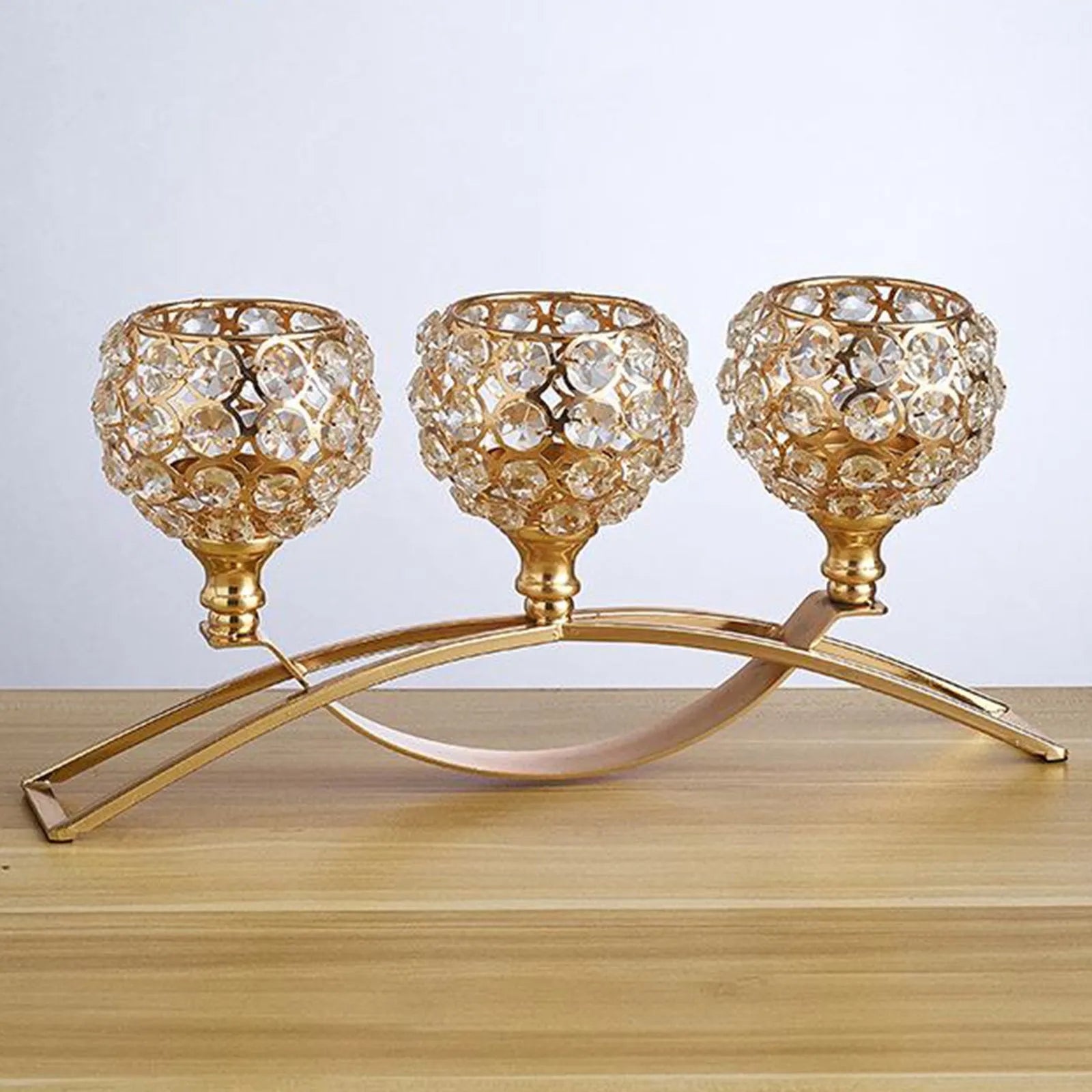 Geometric crystal candle holder with gold electroplated wrought iron frame on a table