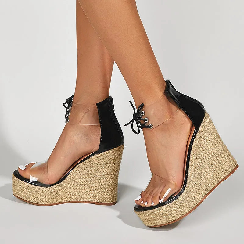Black women's wedge sandals with front tie and high wedge heel on a plain background.