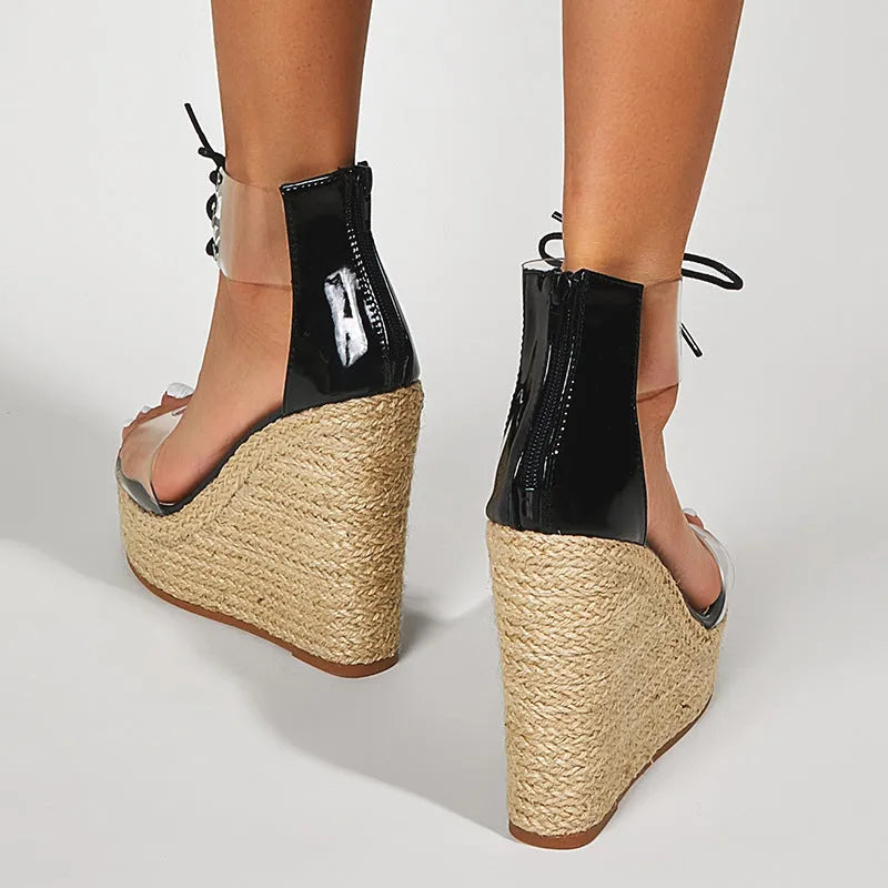 Black women's wedge sandals with front tie and high wedge heel on a plain background.