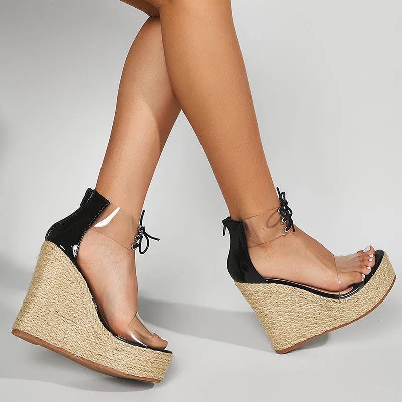 Black women's wedge sandals with front tie and high wedge heel on a plain background.