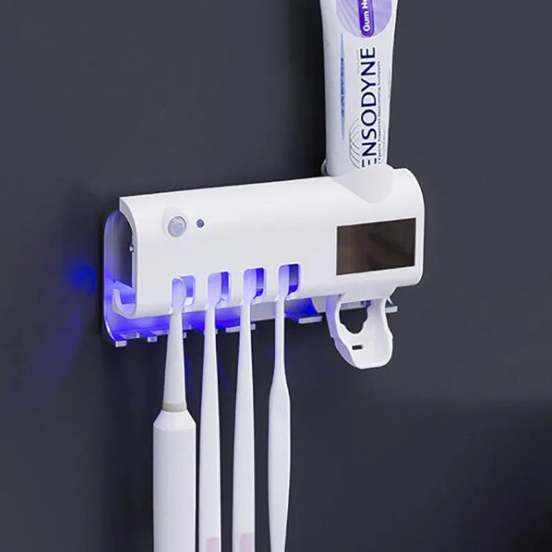 Black wall-mounted UV toothbrush steriliser with automatic toothpaste squeezer on bathroom tiles