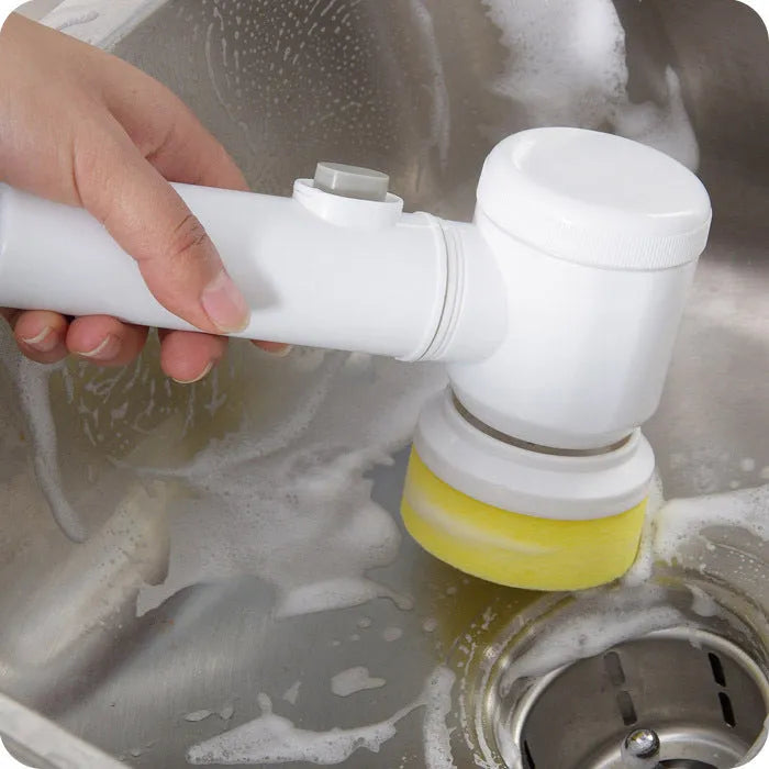 White rechargeable electric cleaning brush with three interchangeable nylon brush heads on a bathroom sink.