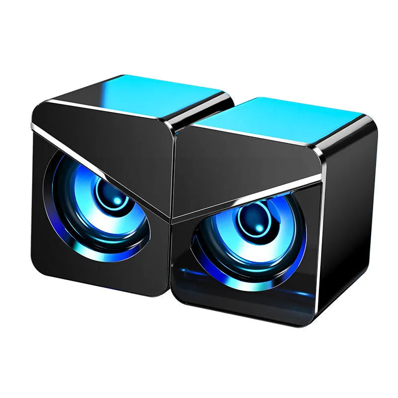 Black and white compact desktop USB speakers with 3.5mm audio jack cable.