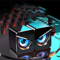 Black and white compact desktop USB speakers with 3.5mm audio jack cable.