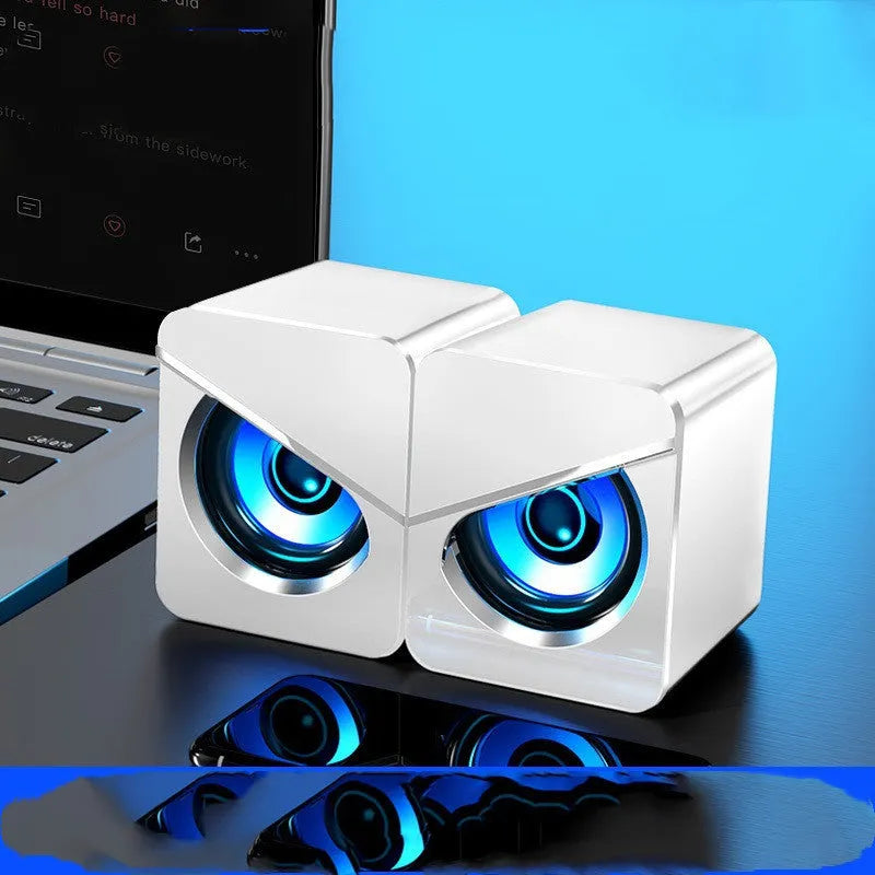 Black and white compact desktop USB speakers with 3.5mm audio jack cable.