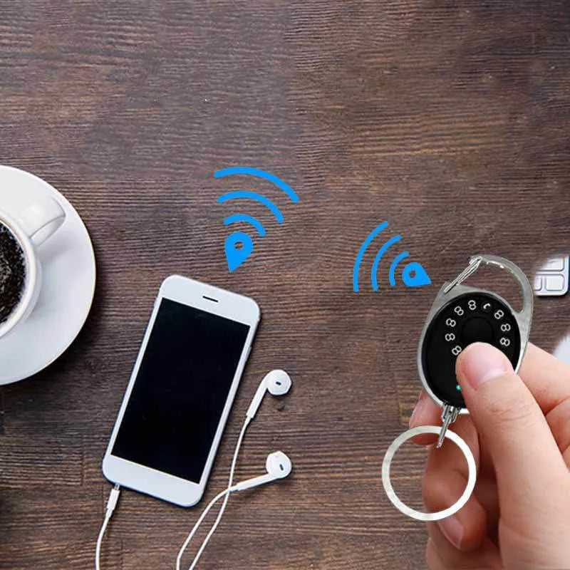 Black ABS plastic Bluetooth anti-lost tracker keychain with metal loop, shown with phone and keys.