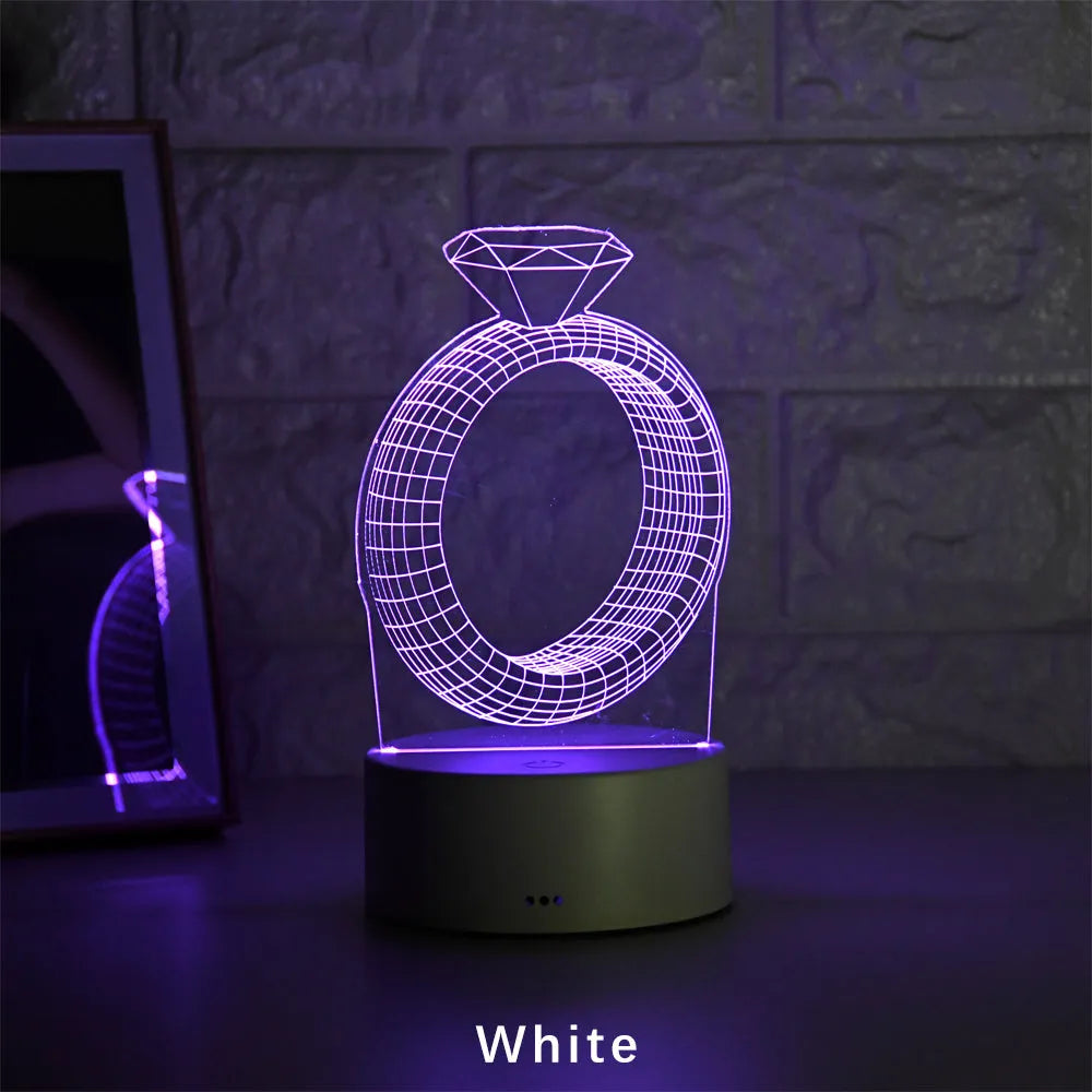 3D LED night light showing holographic diamond ring with colour-changing glow on a black base.