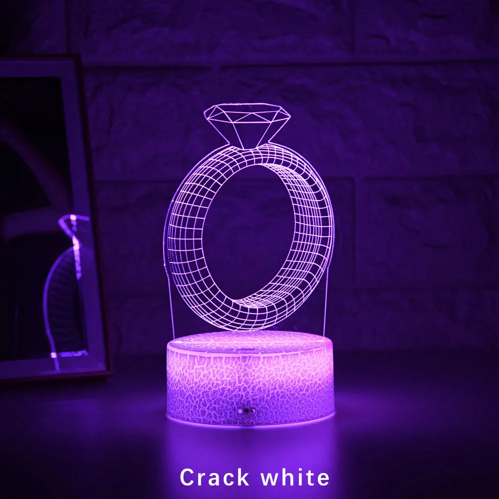 3D LED night light showing holographic diamond ring with colour-changing glow on a black base.