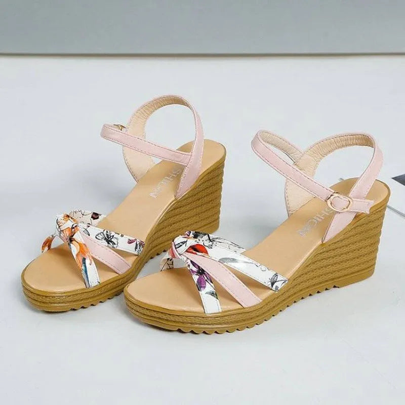Pink women's wedge heel sandals with an adjustable buckle on a white background, showing the non-slip sole pattern.