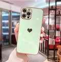 Slim white TPU iPhone case with a silver love heart design and raised protective corners.