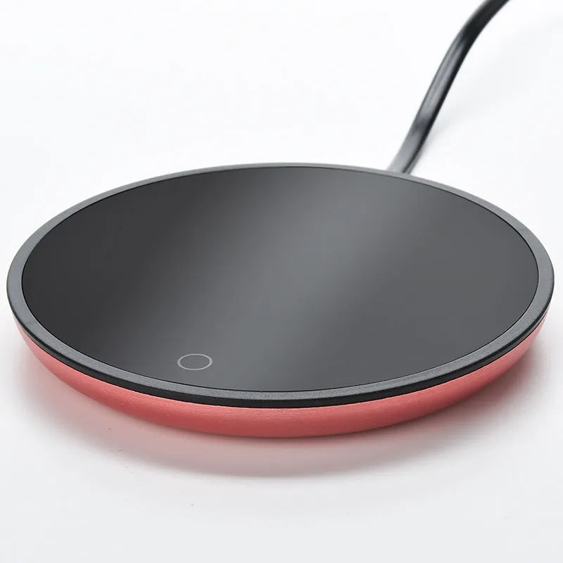 Electric constant temperature cup warmer pad in red colour on a desk with a coffee cup
