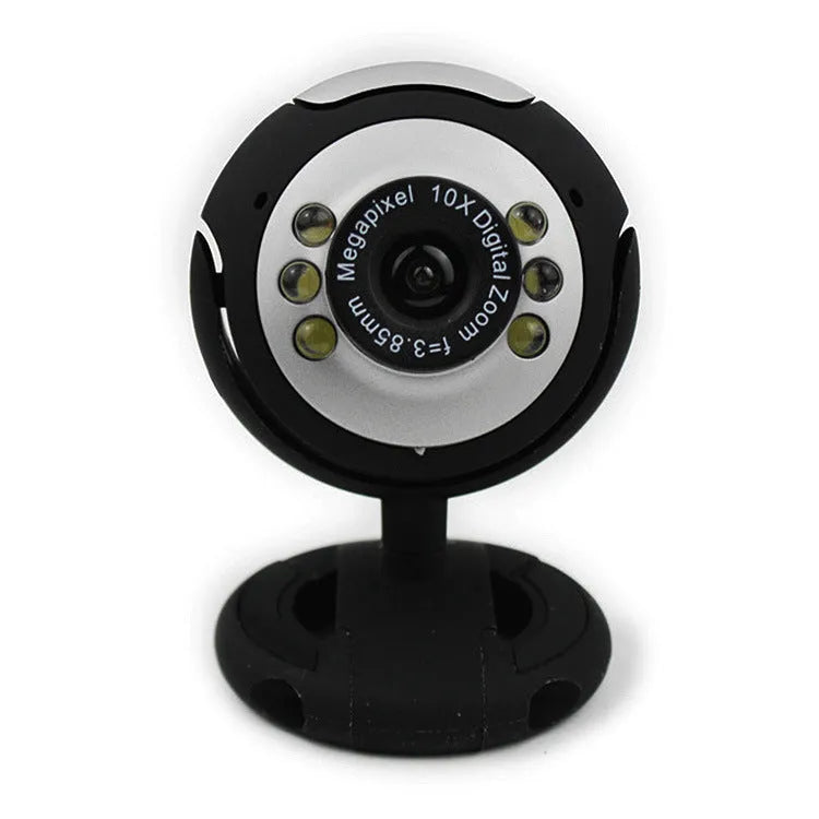 A black computer webcam with a ring of six LED lights around the lens, shown on a desktop.