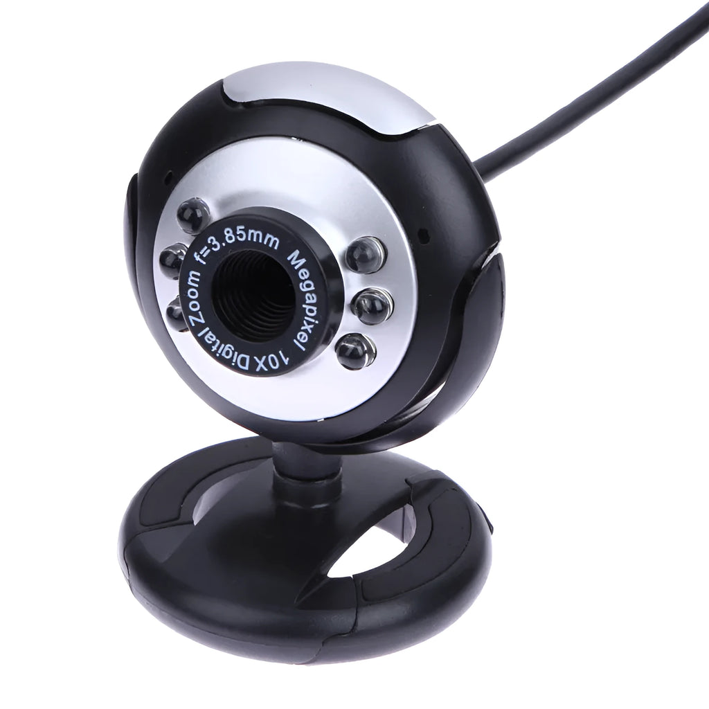 A black computer webcam with a ring of six LED lights around the lens, shown on a desktop.