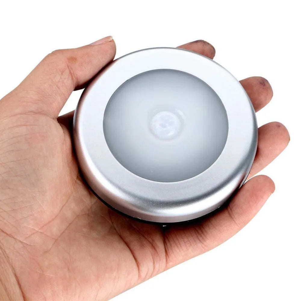 Square black wireless motion sensor night light on a surface, showing compact 80mm size.