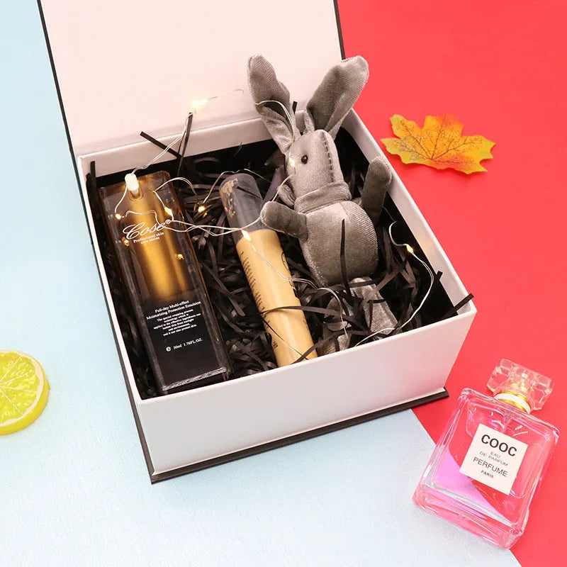 White square clamshell book gift box for lipstick cosmetics, 12x12x6cm size with lid open, on plain background