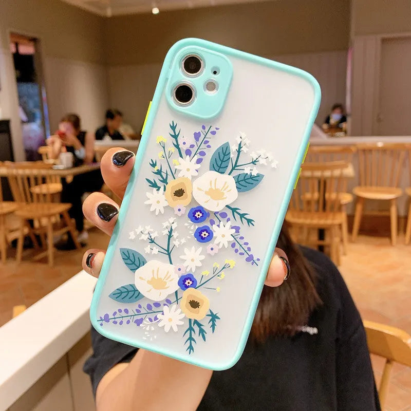 iPhone case with blue flower cartoon design and contrasting pink matte frame on a mobile phone.