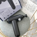 Black USB fascia gun massager for muscle relaxation on a grey background.