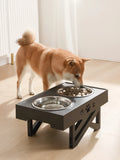 Black folding pet bowl with stainless steel interior and plastic outer shell on surface