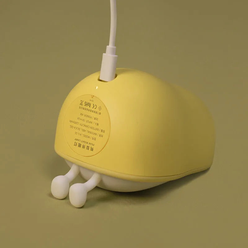 PEAR NIGHT LAMP rechargeable silicone bedside light with warm yellow glow on a surface