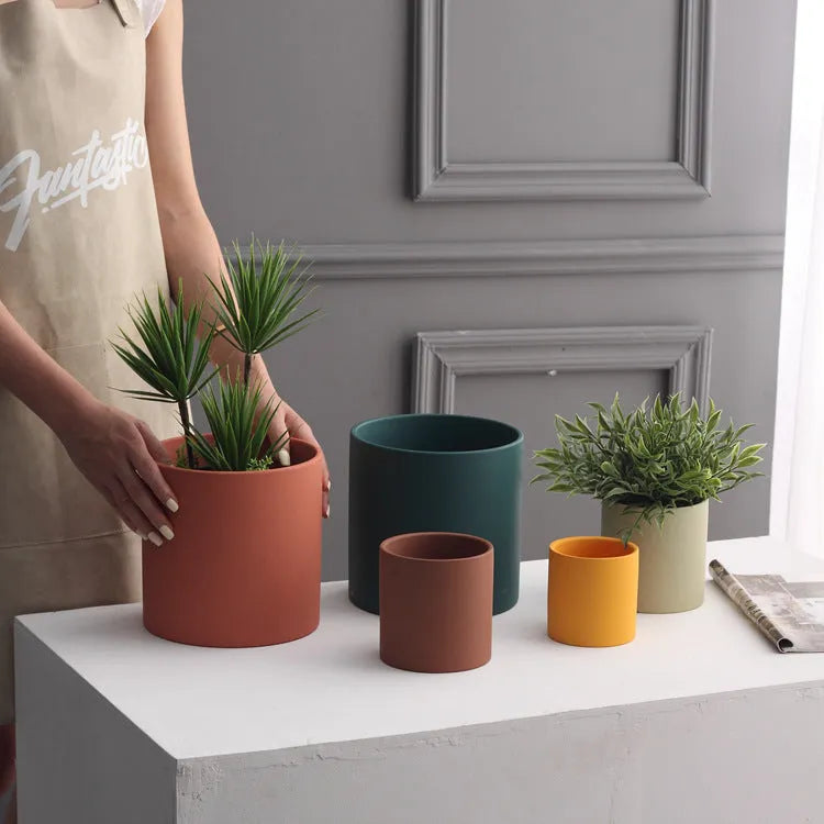 Nordic style cylindrical ceramic cube planter for succulents, shown in a selected colour with visible drainage hole.