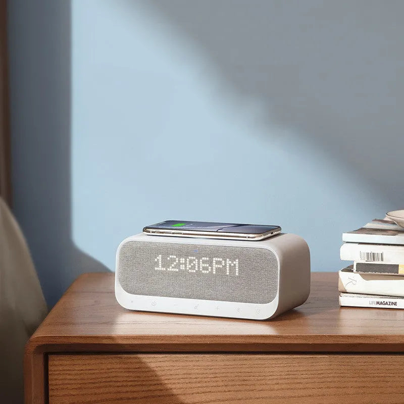 White Anker Soundcore Bluetooth speaker with wireless charging top and digital display.