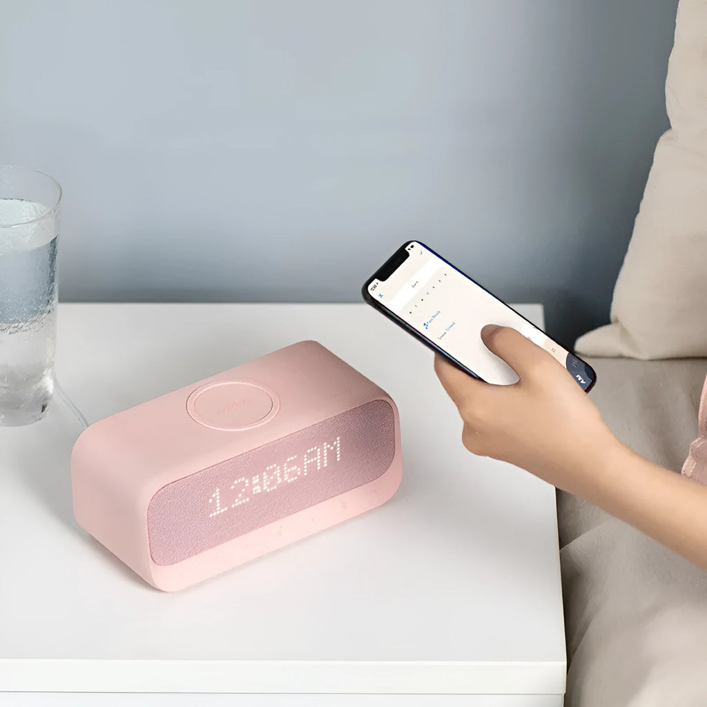 White Anker Soundcore Bluetooth speaker with wireless charging top and digital display.