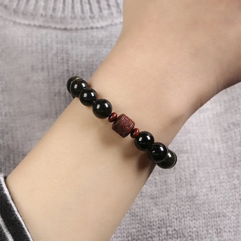 Close-up of a hand-woven Better Luck Beads bracelet with 10mm round Golden Obsidian beads in a retro style.