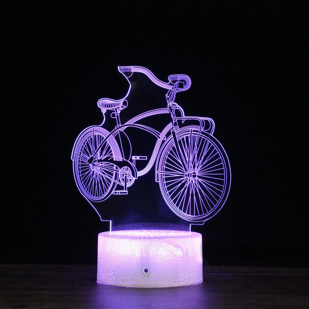 3D bicycle LED night light with acrylic shade and black base on a desk