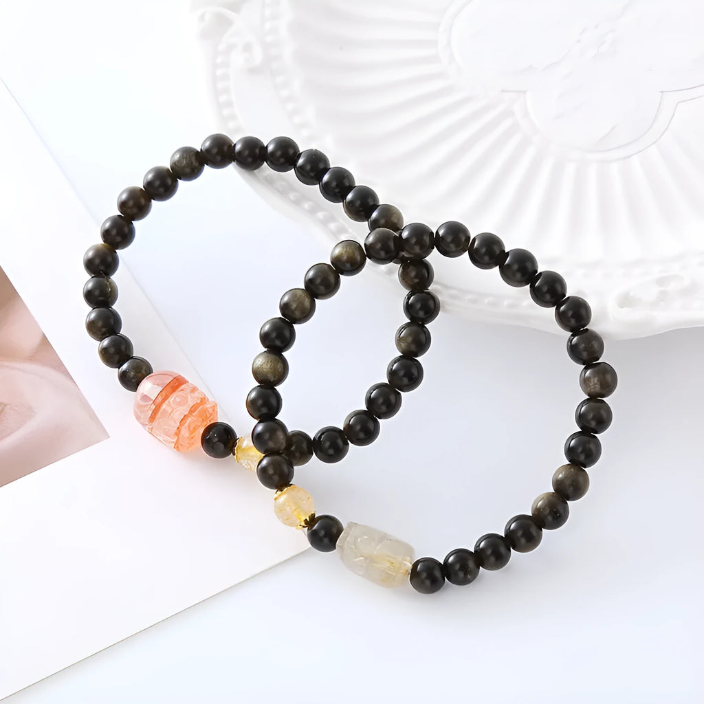 Handcrafted natural obsidian Pi Xiu bracelet with gold and red design on wrist