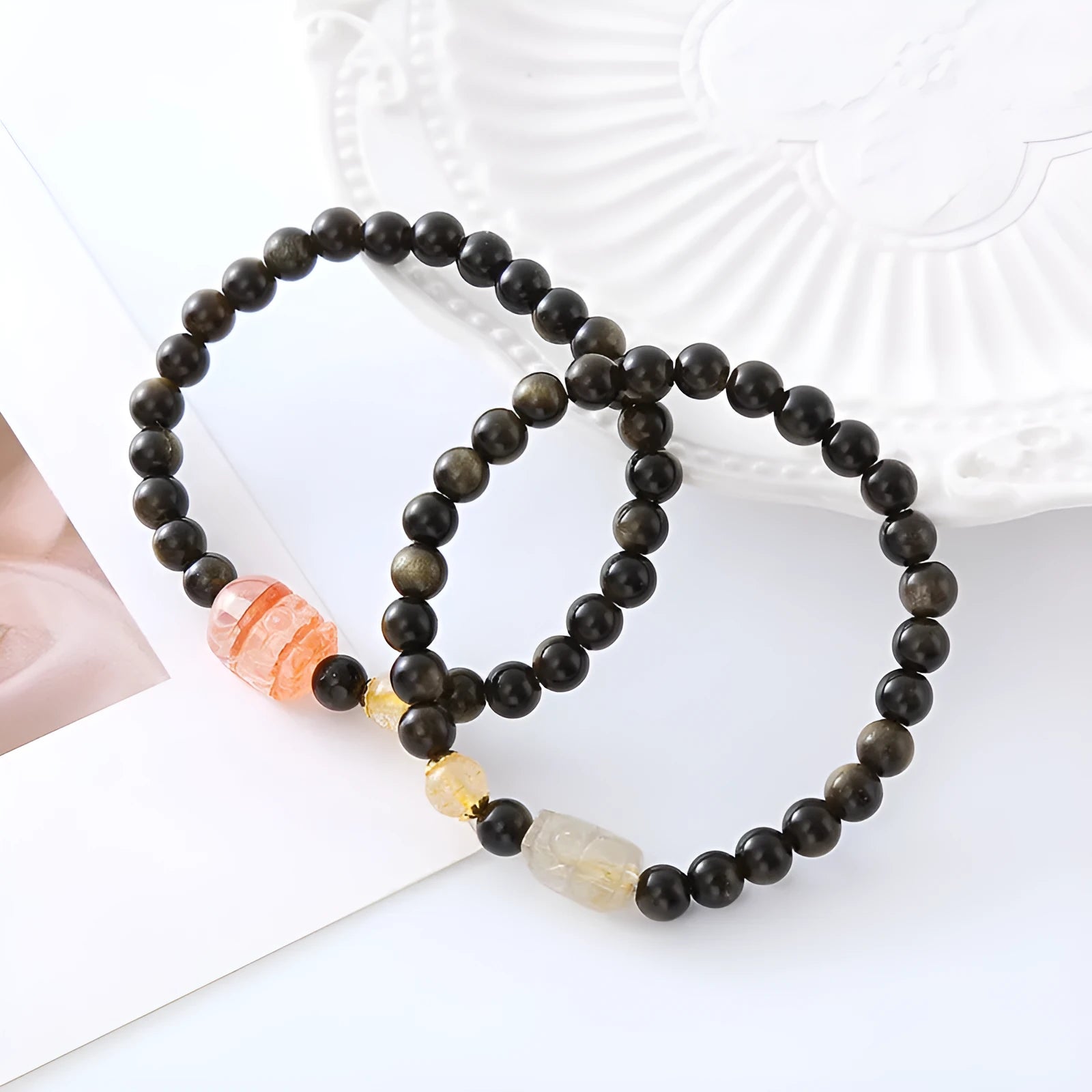 Handcrafted natural obsidian Pi Xiu bracelet with gold and red design on wrist