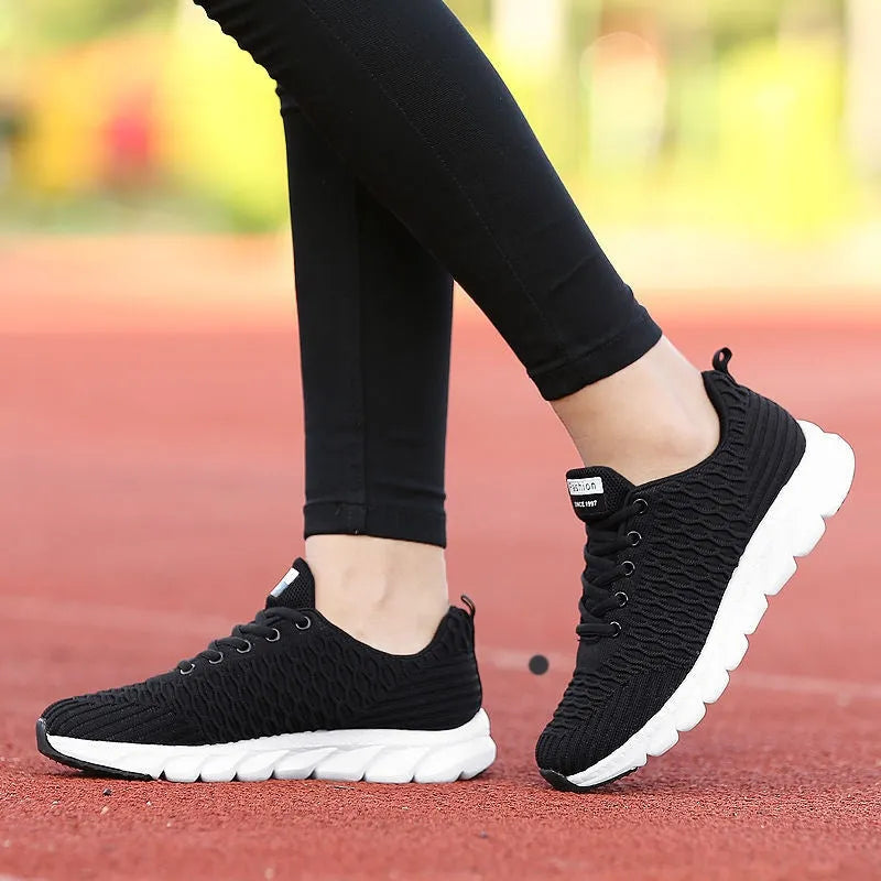 Women's running shoes in black, pink, or white with fly weave upper and wear-resistant outsole