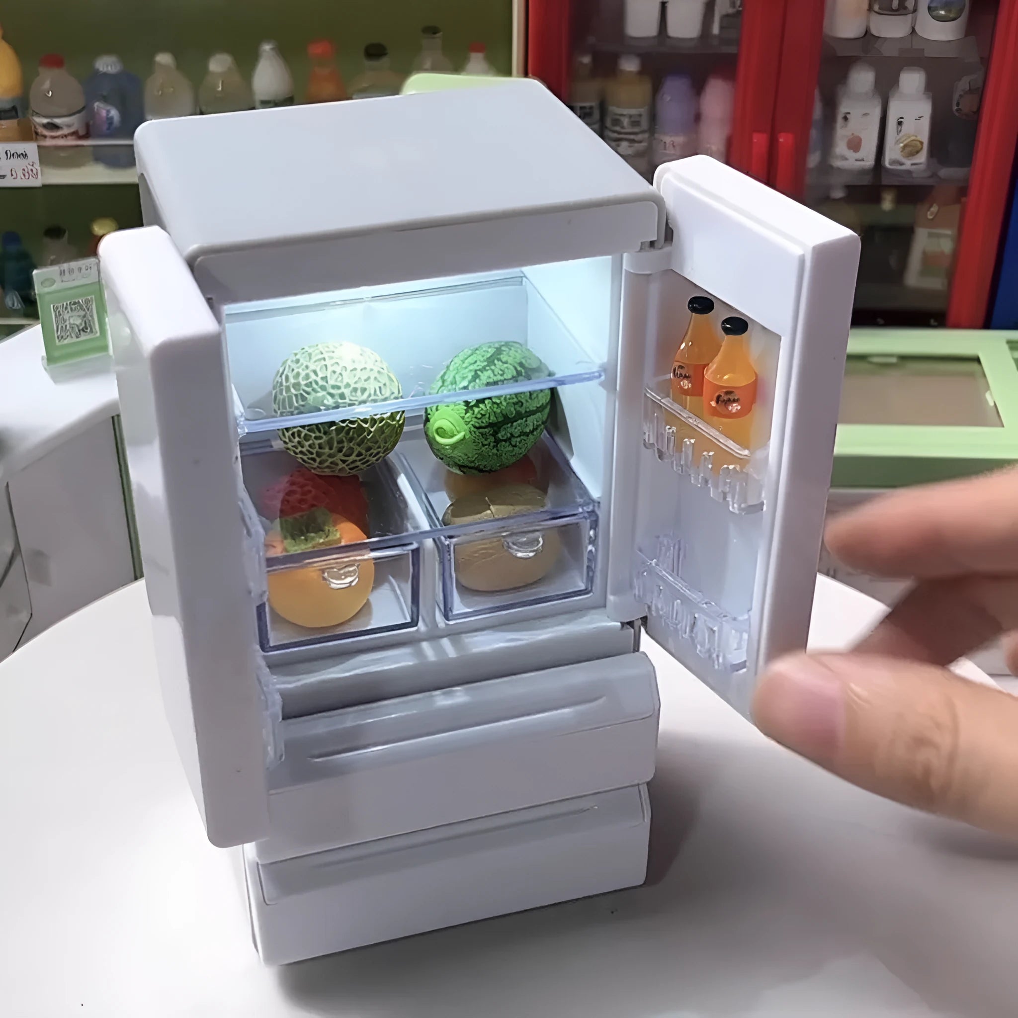 White plastic miniature candy shop model with internal light turned on, showing detailed interior.