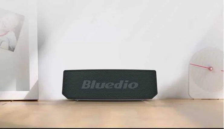Black BS-6 Google Assistant Bluetooth smart speaker on a surface, showing its compact rectangular design.