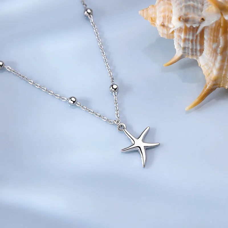 S925 sterling silver starfish charm anklet on a model's ankle, showing 18cm chain and lobster clasp.