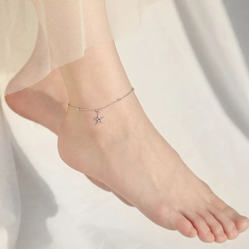 S925 sterling silver starfish charm anklet on a model's ankle, showing 18cm chain and lobster clasp.