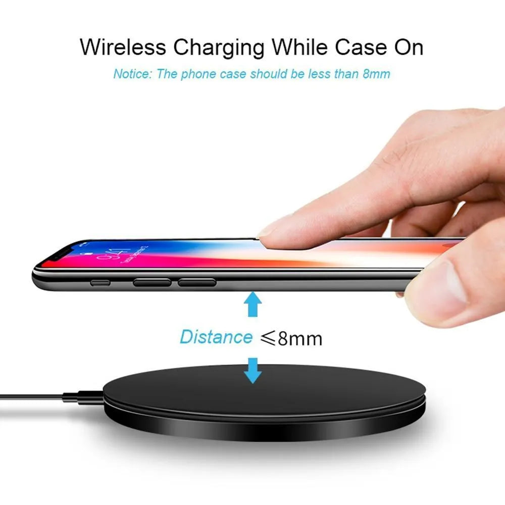 Black square wireless charging pad on desk with smartphone charging wirelessly