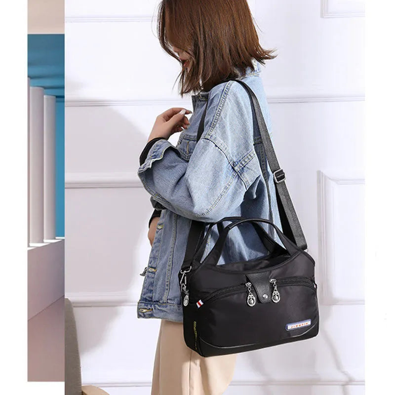 Women's crossbody bag in Oxford cloth with zippered closure and adjustable shoulder strap, 29cm long, available in multiple colours